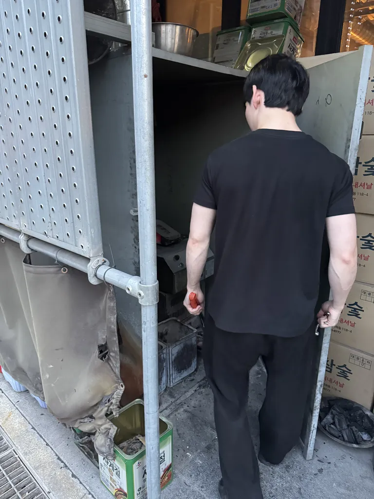 신촌 창돈 입구에서 숯불을 피우는 직원