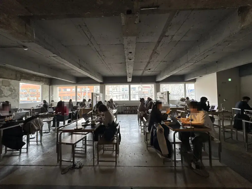 넓은 공간에서 각자 작업에 몰두하는 사람들