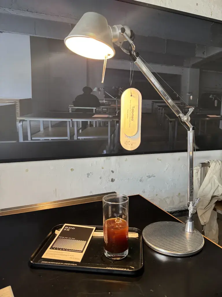 앉은 자리에서 본 테이블 램프의 빛과 커피